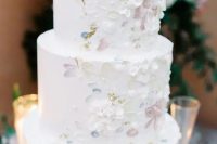 a white wedding cake with sugar blooms and brushstrokes is a fantastic idea for a spring or summer wedding