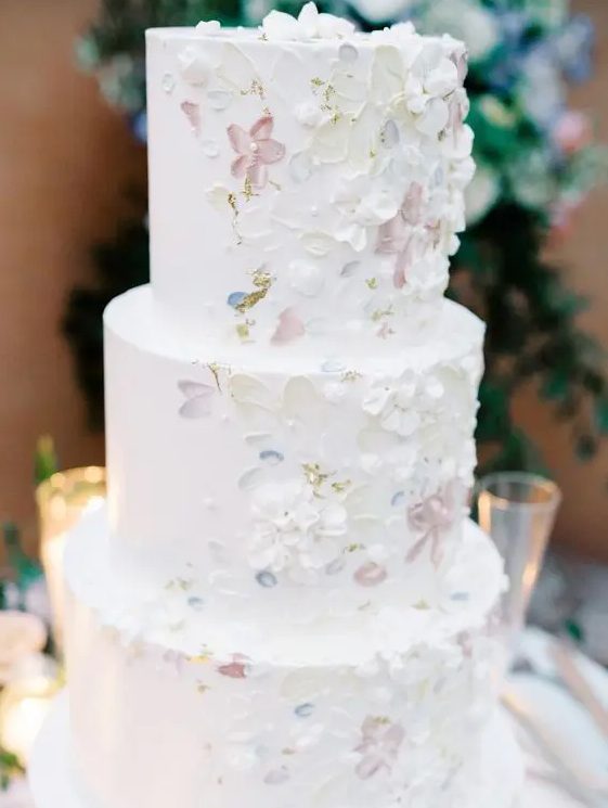 a white wedding cake with sugar blooms and brushstrokes is a fantastic idea for a spring or summer wedding