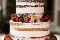 a yummy-looking naked four tier wedding cake topped with fresh berries and with a sugar dog topper is a fantastic idea