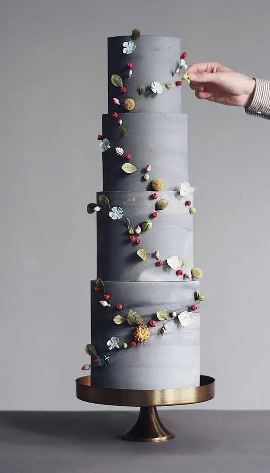 an adorable grey wedding cake decorated with dried blooms and sugar flowers is a stylish and catchy idea for a wedding