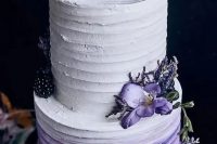 an ombre white to purple wedding cake topped with purple blooms, with blackberries and blueberries is a bold and cool idea for your wedding