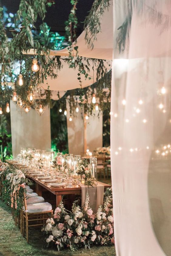 04 an enchanting outdoor wedding reception with a white fabric canopy, some greenery and bulbs hanging down