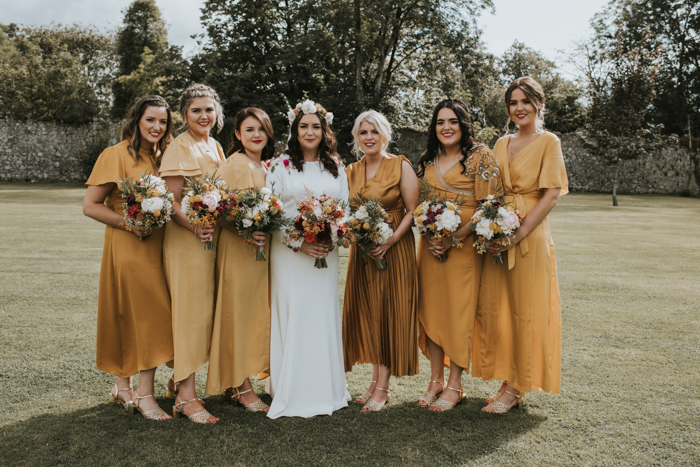 The bridesmaids were wearing mismatching ochre dresses of their choice and neutral shoes