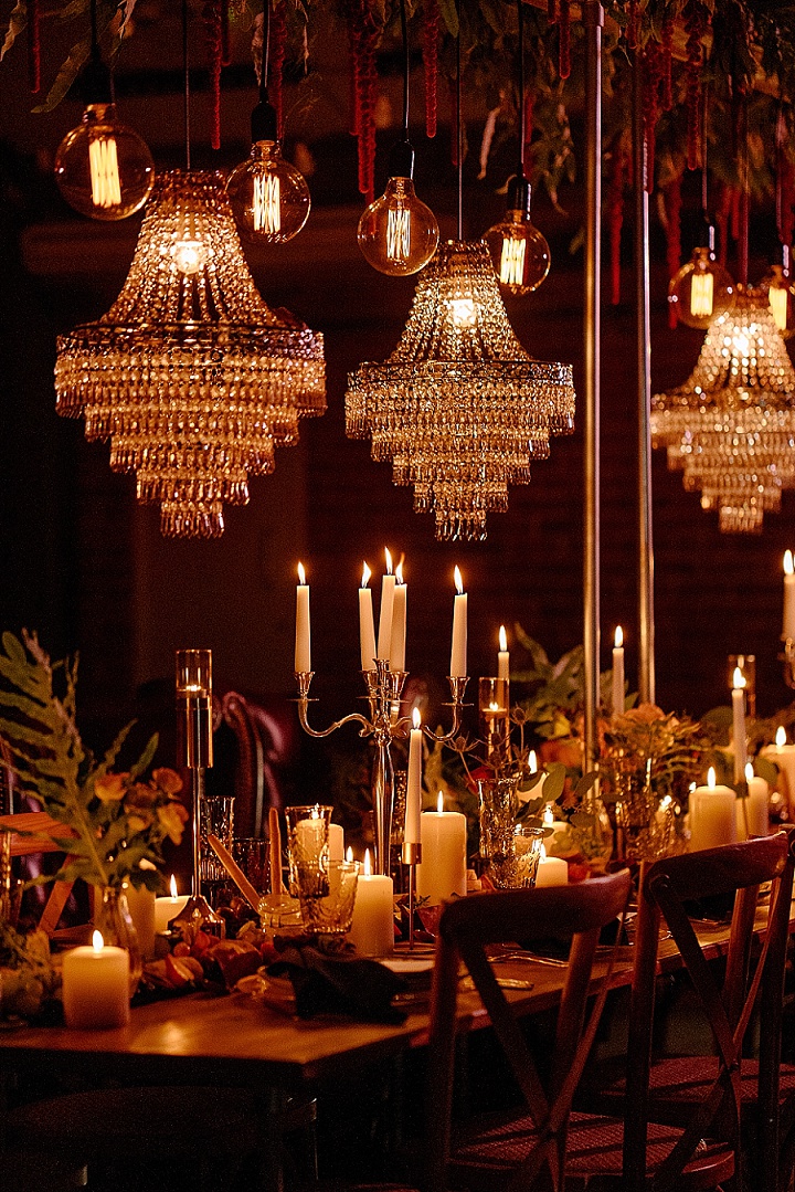 The wedding tablescape was lit up with crystal chandeliers, candles, greenery and bold blooms