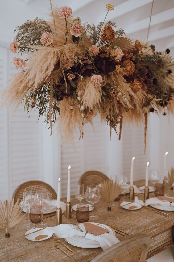a beautiful wedding overhead installation of blush and dried blooms, pampas and other grasses and fronds is chic