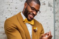 a chic mustard groom’s look with a suit, a white shirt, a yellow bow tie, a bold boutonniere is a lovely idea