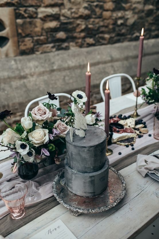 a grey concrete-styled wedding cake topped with white blooms and grasses is an ultra-modern wedding idea