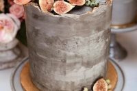 a grey concrete wedding cake with a raw edge and gold touches, pink blooms, figs and berries is adorable for a modern wedding