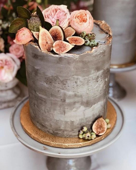 a grey concrete wedding cake with a raw edge and gold touches, pink blooms, figs and berries is adorable for a modern wedding