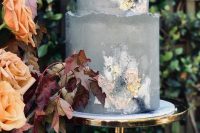 a grey concrete wedding cake with a raw edge and some textural pastel watercolors resembling blooms is a very refined idea