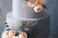 a grey concrete wedding cake with an ombre effect, blush blooms, greenery and gold foil is a lovely idea for a modern wedding