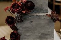 a grey concrete wedding cake with bold burgundy blooms and bold leaves is amazing for a fall wedding