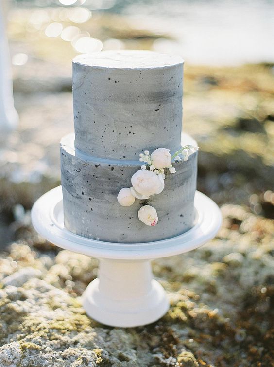 a grey concrete wedding cake with neutral blooms is a stylish idea for many wedding styles