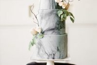 a grey marble wedding cake decorated with neutral blooms and greeneris a lovely idea for a modern wedding