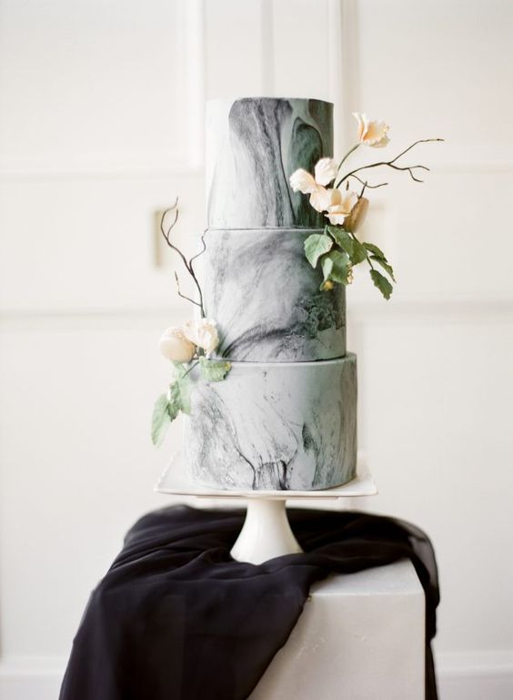 a grey marble wedding cake decorated with neutral blooms and greeneris a lovely idea for a modern wedding