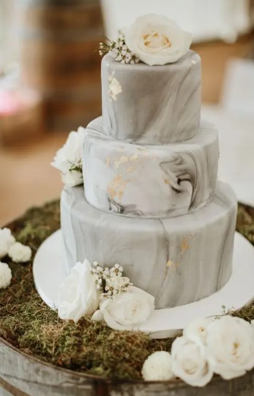 a grey marble wedding cake with gold leaf and white blooms is pure and timeless elegance