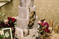 a grey marble wedding cake with gold leaf is a stylish and statement idea for a modern refined wedding