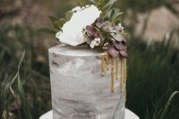 a grey watercolor wedding cake with gold drip, white blooms and green and purple succulents for a modern wedding