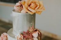 a grey wedding cake topped with pink, orange blooms and amaranthus for a modern wedding with a bold color scheme