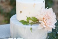 a lovely wedding cake with a white and a grey marble tier, with gold leaf and a large blush bloom is amazing for a spring wedding
