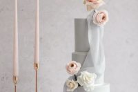 a minimalist grey wedding cake with blush and white roses and ranunculus is a beautiful and refined idea for a wedding