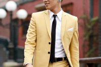 a modern and catchy gorom’s look with a yellow suit, a white shirt, a black tie and black belt is a bold idea