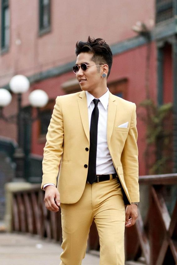 a modern and catchy gorom's look with a yellow suit, a white shirt, a black tie and black belt is a bold idea