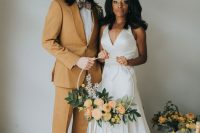 a modern groom’s look with a mustard tuxedo, a white shirt, a printed bow tie and brown shoes