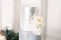 a refined and glam wedding cake with a silver foil tier and a grey marble one plus some white blooms is a lovely idea