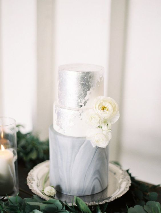 a refined and glam wedding cake with a silver foil tier and a grey marble one plus some white blooms is a lovely idea