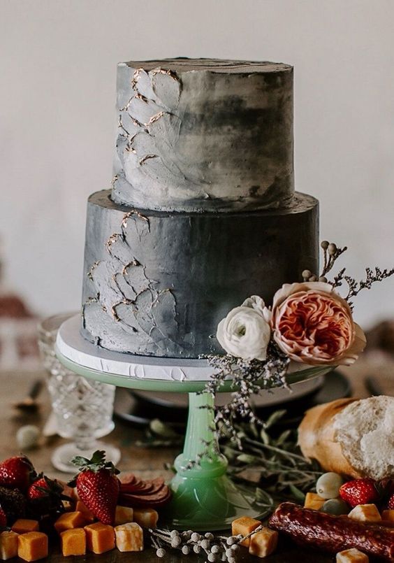 A textured grey wedding cake with gold touches and neutral blooms is an eye catchy idea for a fall wedding