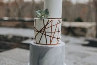 a white and grey marble wedding cake with copper touches and a succulent is a cool modern idea