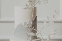 an ethereal white and grey wedding cake with sleek and textured tiers and white dried branches is a chic idea for a modern wedding