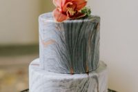an exquisite wedding cake with grey marble tiers, copper leaf and a bold tropical bloom and a pineapple topper is cool