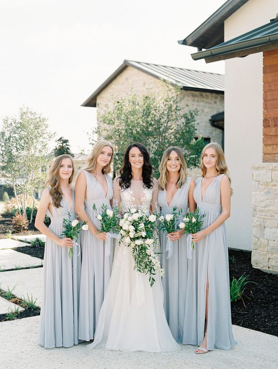 matching dove grey maxi pleated bridesmaid dresses with draped bodices and pleated skirts and deep necklines for a summer wedding