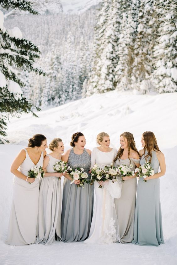 mismatching dove grey and silver grey bridesmaid gowns for an elegant and chic look at a winter wedding