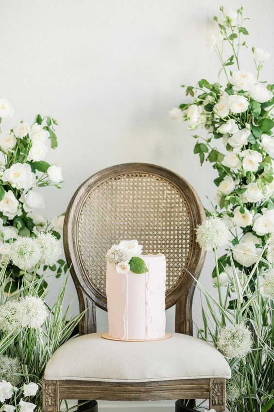 a lovely blush buttercream wedding cake with texture and blush blooms and a leaf for a refined spring wedding