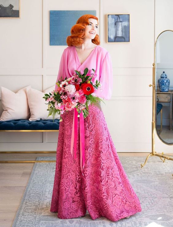 a bold rose wedding dress with a plain bodice with a V-neckline and bell sleeves and a lace A-line skirt
