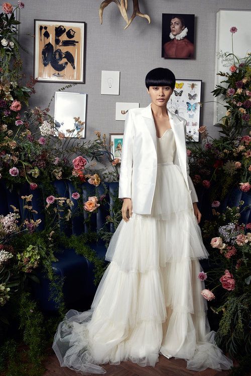 a strapless wedding ballgown with a tiered skirt, a train and a white oversized blazer for a coverup