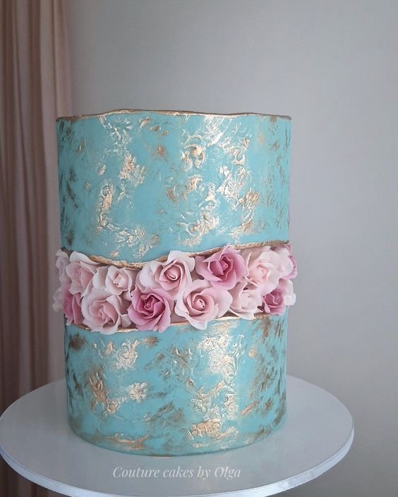 a refined blue wedding cake with gold touches, a gold edge and a pink rose fault line for a beautiful look