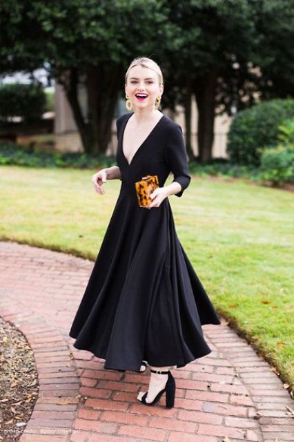 a black maxi dress with a pleated skirt, a plunging neckline and long sleeves, block heels and an animal print clutch, which is a trend