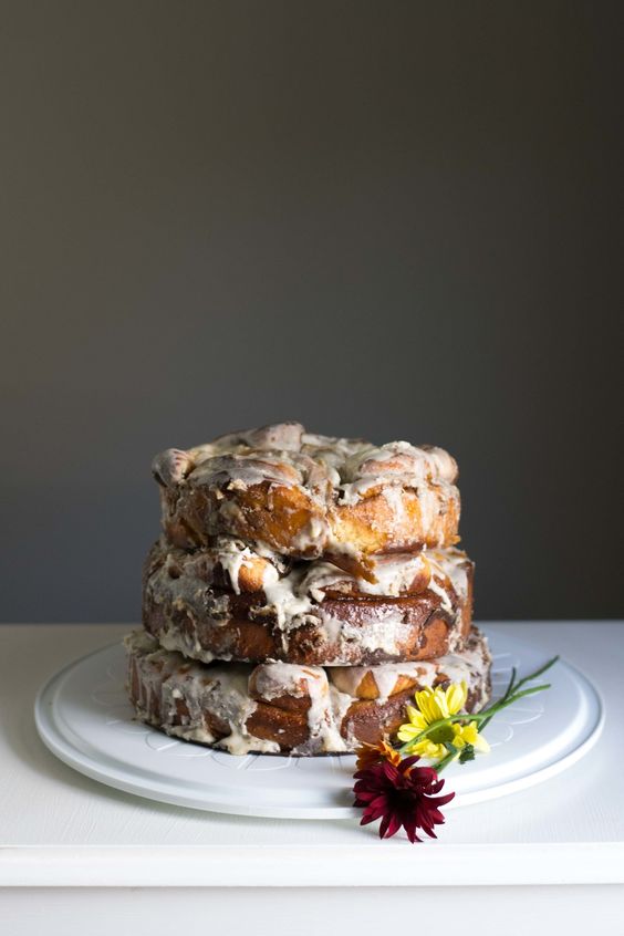 a cinnamon roll stacked wedding cake with some bright blooms is a delicious alternative to a usual wedding cake
