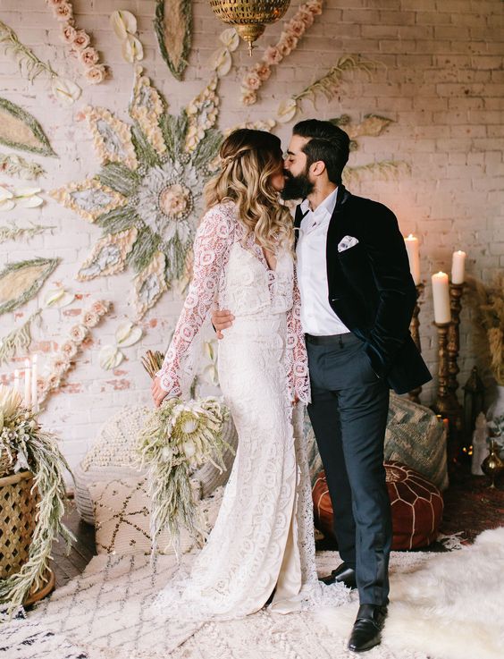 a unique flower child backdrop on the wall made of blooms, foliage and yarn is ideal for a 70s boho wedding
