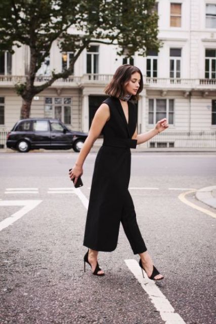 black cropped pants, a black sleeveless waistcoat with a sash, catchy black heels and a tiny clutch