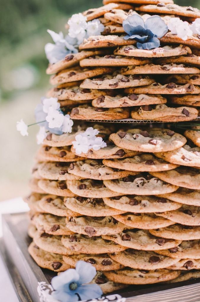 a chocolate chip cookie stacked wedding cake decorated with white and blue blooms is a very elegant and refined idea