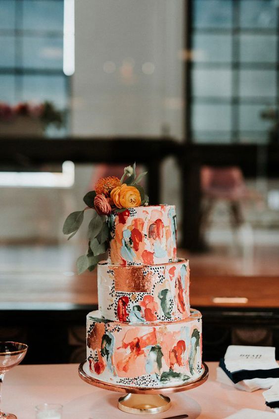 a colorful wedding cake with bold brushstrokes, copper leaf, bright blooms and leaves is a cool idea for a vivacious wedding