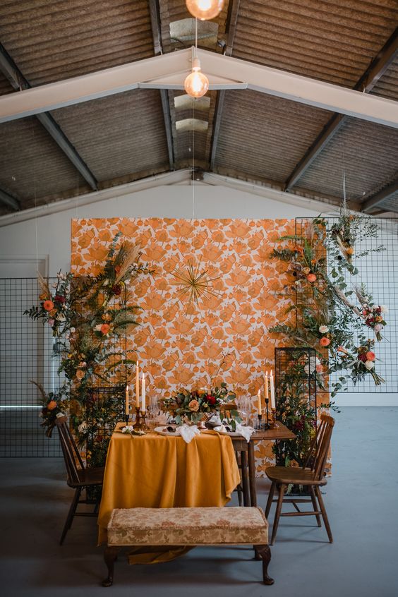 a bright floral wallpaper backdrop, some greenery and bold blooms for a lovely mid-century wedding