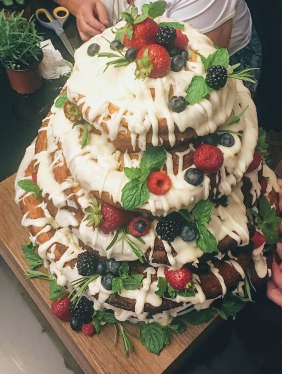 an oversized cinnamon roll wedding cake with white icing, mint, fresh berries is a fantastic idea for summer weddings