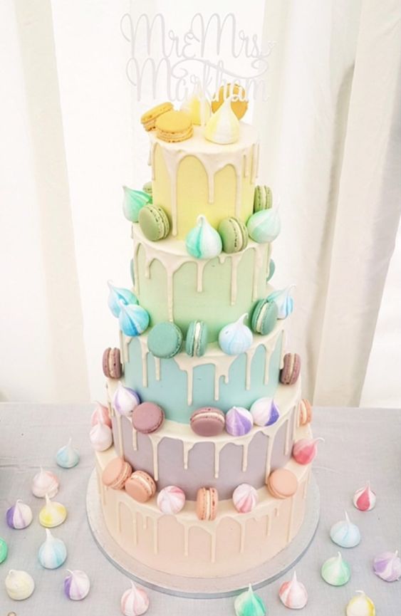 a multi-tier wedding cake with each tier done in various pastel shades, with colorful macarons and meringues is a lovely idea