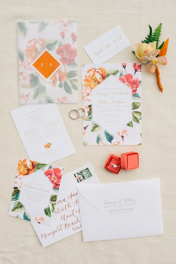 a bright tropical invitation suite with bold floral prints and a semi sheer envelope is a stylish idea for a colorful wedding